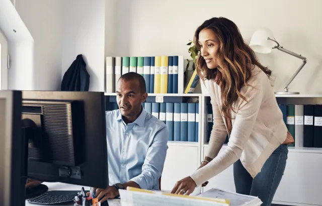 Woman and man looking at something on the computer with interest
