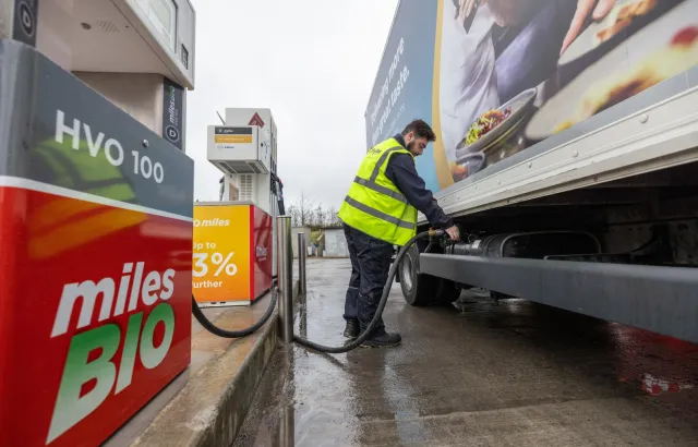 A person filling a truck with a hose at a Circle K station